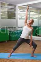 Fit young woman doing stretching exercise in gym