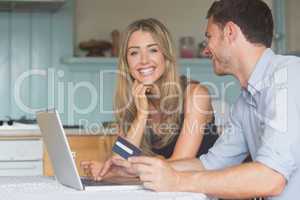Cute couple using laptop together to shop online
