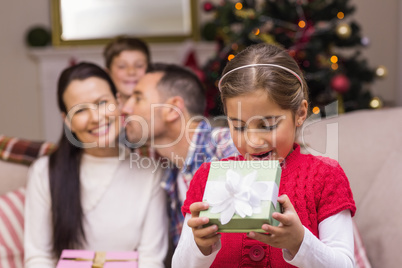 Surprised little girl opening a gift