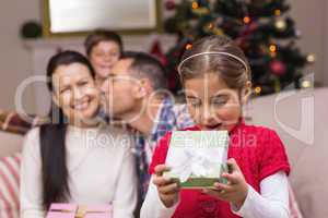Surprised little girl opening a gift