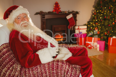 Smiling santa sitting and holding his belly