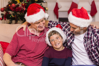 Portrait of grandfather father and son in santa hats