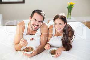 Young couple having breakfast in bed