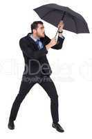 Businessman holding umbrella to protect himself