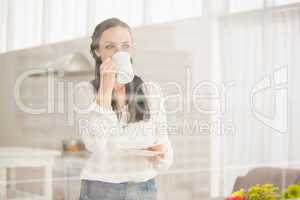 Pretty brunette holding a mug and cookie