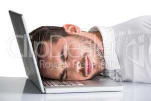 Cheerful businessman resting head on his laptop
