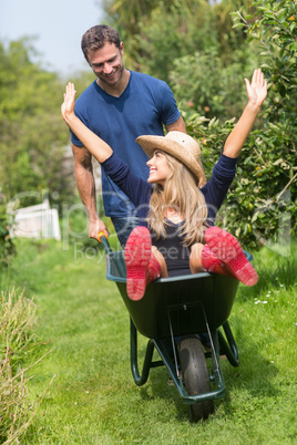 Man pushing his girlfriend in a wheelbarrow