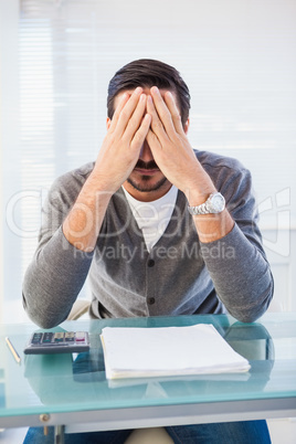 Worried businessman with head in hands