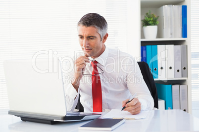 Businessman holding his glasses and take notes