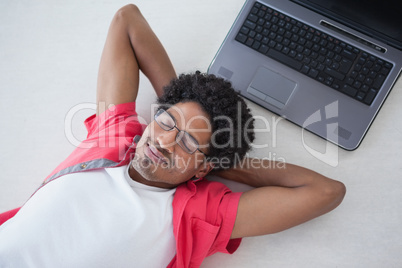 Businessman napping on floor near laptop