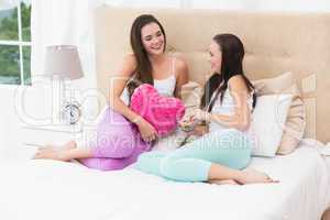 Pretty friends chatting on bed