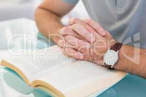 Casual businessman sitting at desk reading a book