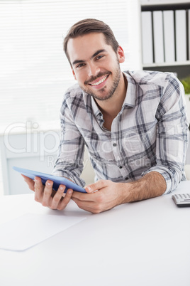 Casual businessman using tablet at desk