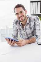 Casual businessman using tablet at desk