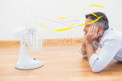 Man lying in front of an electronic fan with ribbons