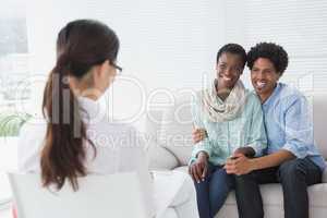 Reconciled couple smiling at their therapist