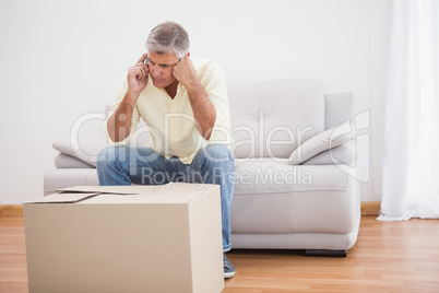 Man talking on phone looking at box