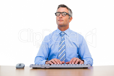 Concentrated businessman with glasses typing on keyboard