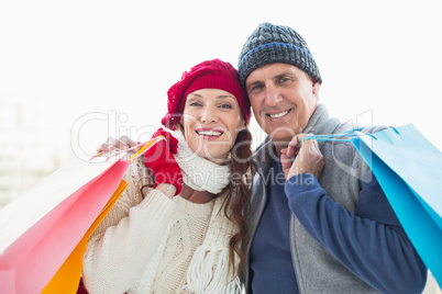 Happy couple in warm clothing with shopping bags