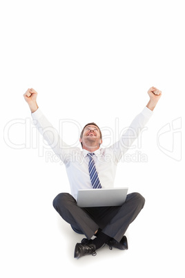 Excited cheering businessman sitting using his laptop