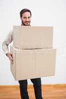 Smiling man holding a cardboard moving box