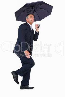 Businessman in suit standing under umbrella