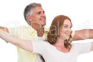 Casual couple smiling with arms raised