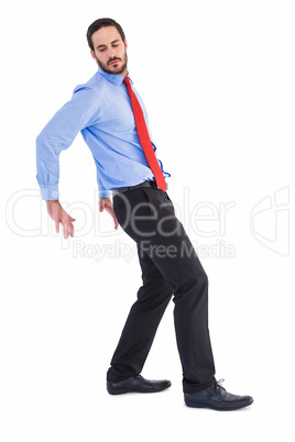 Focused businessman standing and pushing with hands