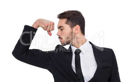 Cheerful businessman tensing arm muscle