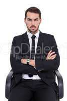 Serious businessman sitting with arms crossed