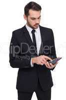 Concentrated businessman in suit using calculator