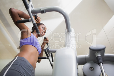 Fit woman using the weights machine for her arms