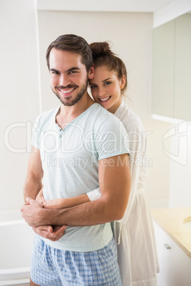 Young couple hugging and smiling at camera