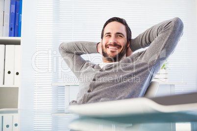 Relaxed casual businessman leaning back at his desk