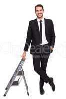 Smiling businessman leaning on stepladder