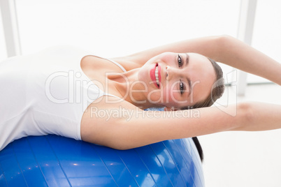 Fit brunette stretching on an exercise ball