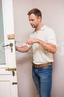 Man fixing the door handle with screwdriver