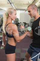 Couple exercising with dumbbells in gym