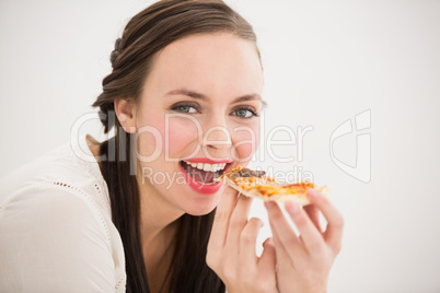Pretty brunette eating slice of pizza