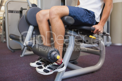 Fit man using weights machine for legs