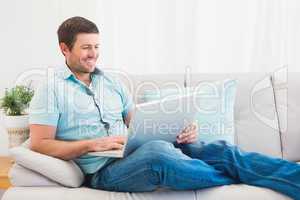 Relaxing man on a sofa with a laptop