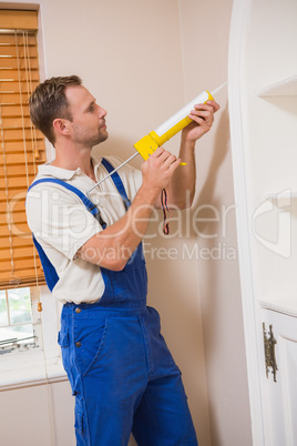 Man putting filling between door and wall