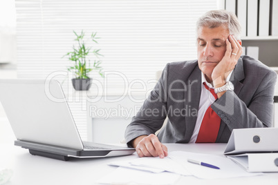 Tired businessman falling asleep at desk