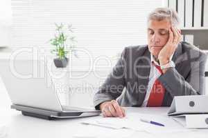 Tired businessman falling asleep at desk