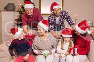 Happy extended family in santa hat holding gifts