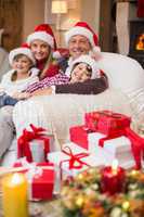 Festive family in santa hat hugging on couch