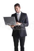 Smiling businessman standing using laptop