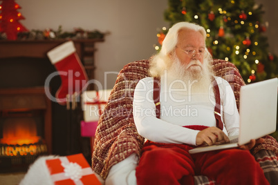 Santa claus typing on laptop