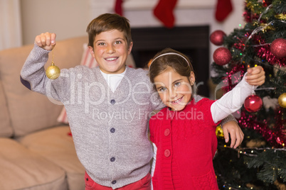 Happy brother and sister holding baubles