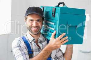 Plumber holding toolbox on shoulder